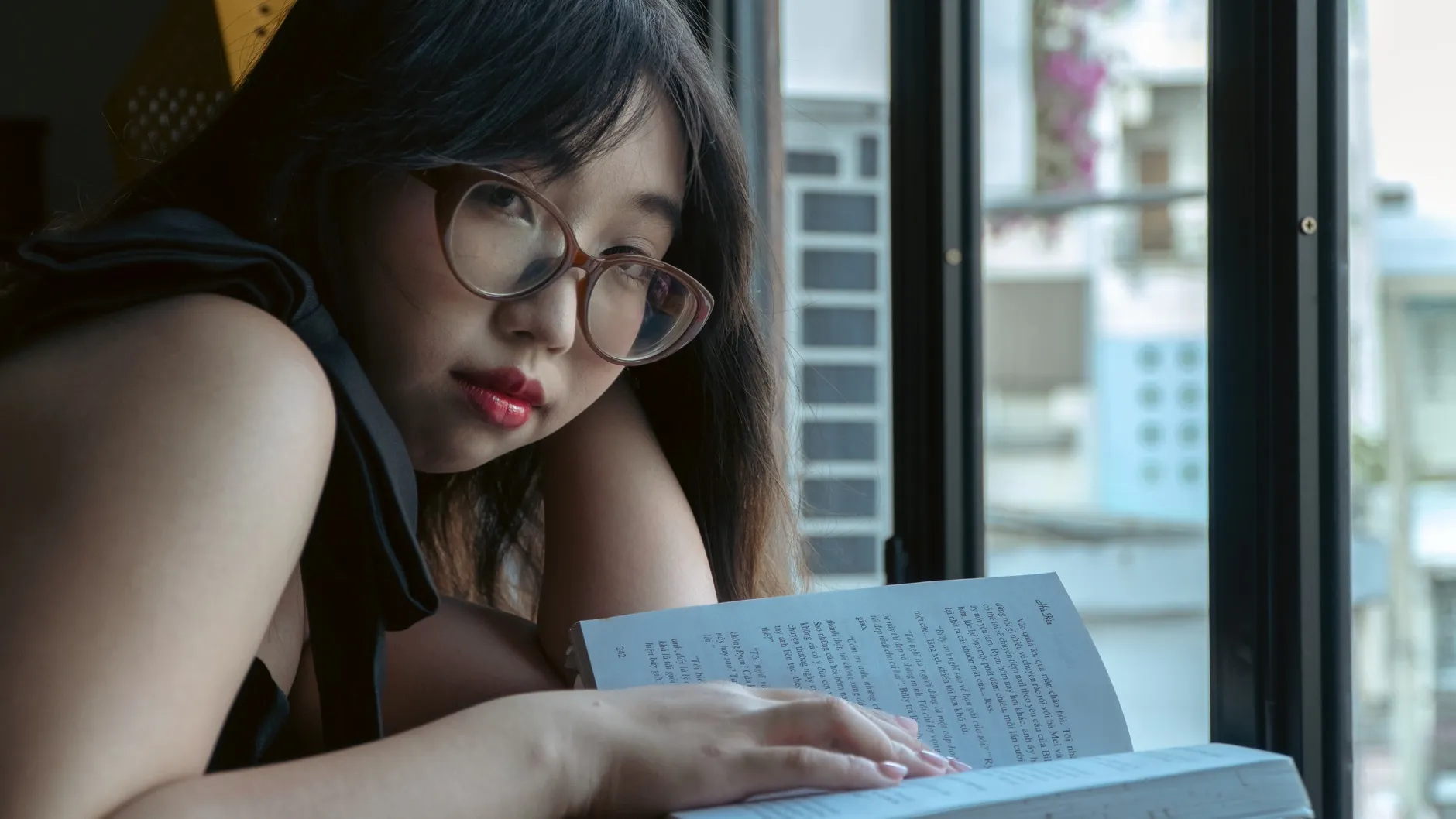 A woman reading by a window on a quiet afternoon