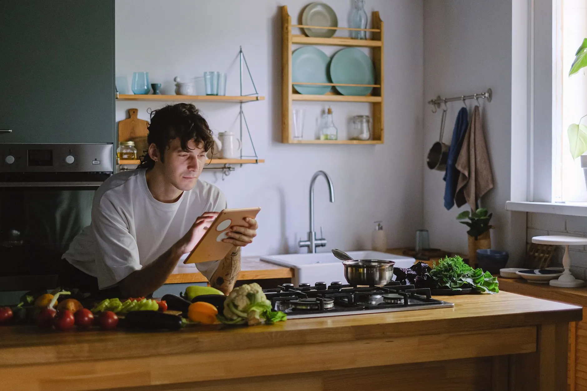 A man preparing fresh vegetables in a sunlit kitchen