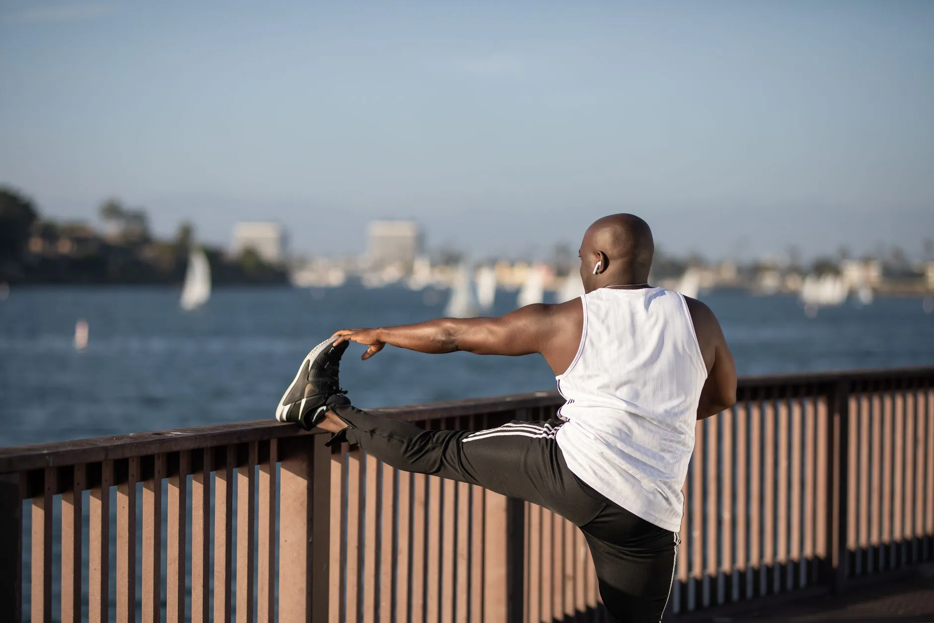 A man stretching by the water after a run